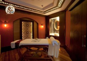 Pat de masaj cu prosoape albe într-o cameră spa elegantă, pregătit pentru programul de masaj Cleopatra în Hurghada.