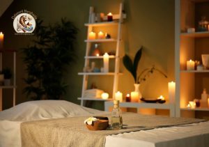 Masă de masaj pregătită pentru o ședință de masaj cu pietre fierbinți, într-o atmosferă relaxantă cu lumânări aprinse.