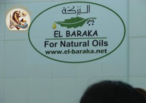 Logo El Baraka pentru Uleiuri Naturale pe peretele fabricii, cu inscripția „El Baraka For Natural Oils” și adresa site-ului oficial.