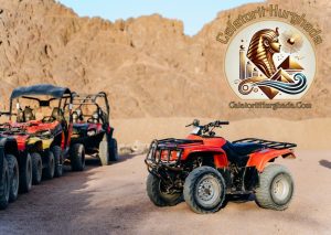 Flotă de ATV-uri roșii și vehicule buggy parcate la baza munților stâncoși, pregătite pentru o Excursie Safari în Deșert.