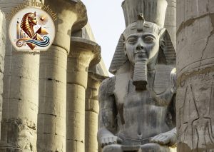 Statuie colosală a lui Ramses al II-lea în interiorul Templului Luxor, un obiectiv principal din această Excursie Luxor: Ghid Complet, flancată de coloane masive din piatră.